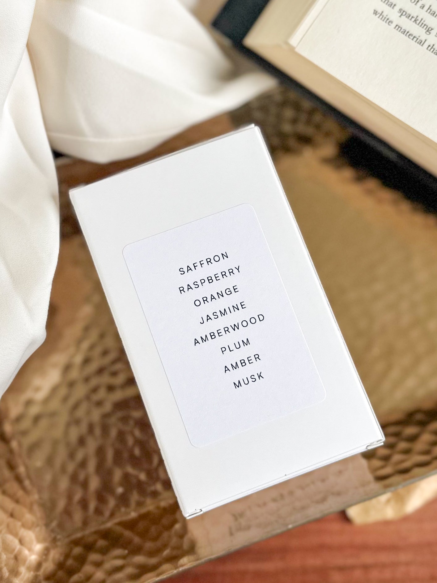 White box with fragrance name on a textured surface