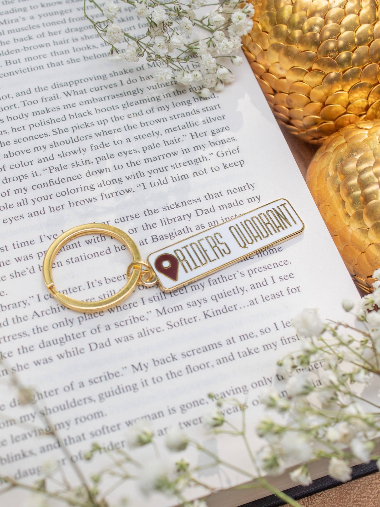 Riders Quadrant Location Keychain by Meaggie Moos hard enamel keychain with gold metal accents on book