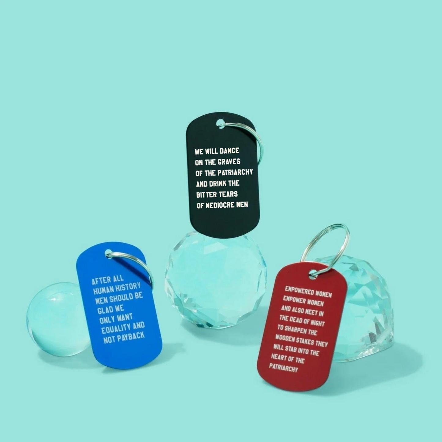 Three glass bells with text tags on a teal background