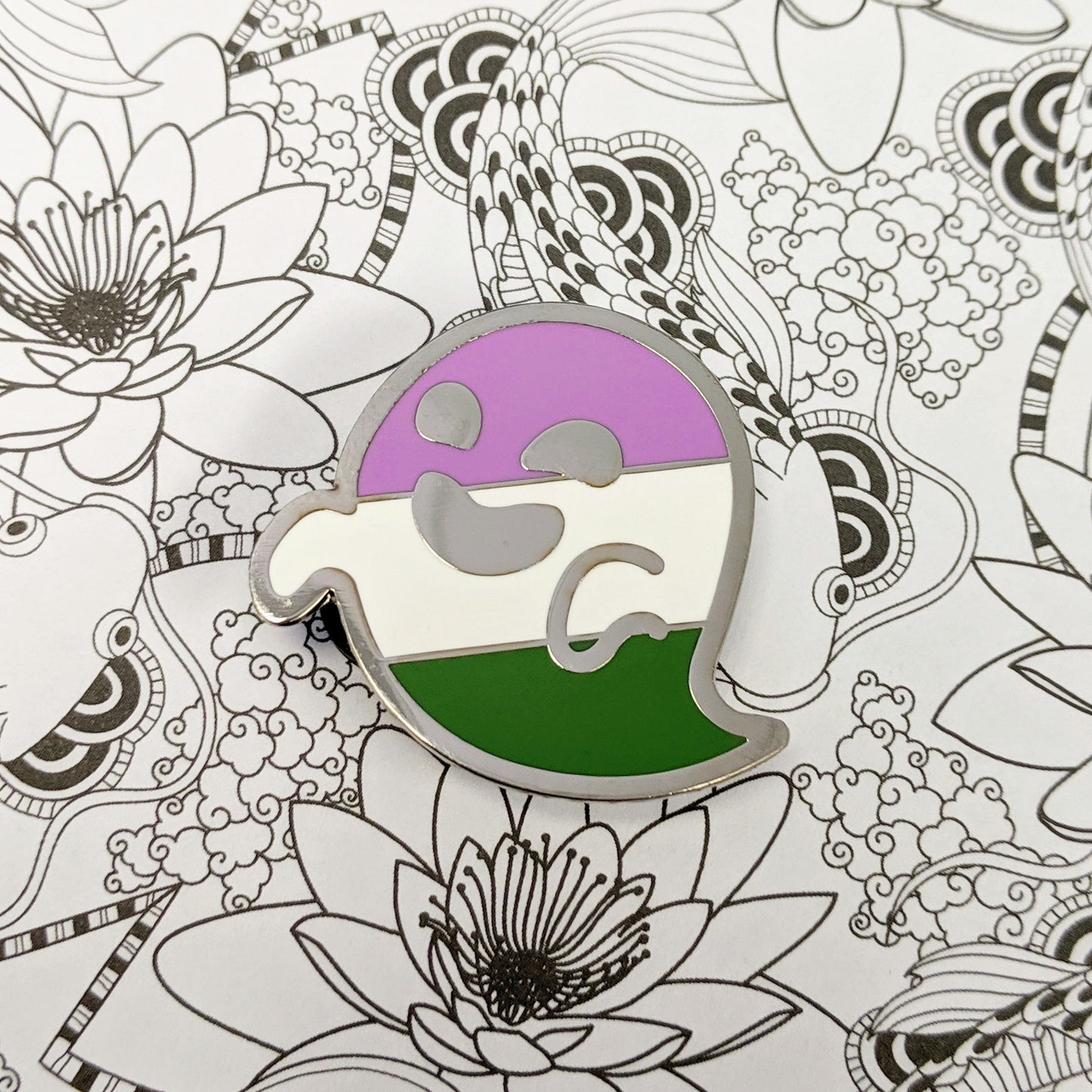 Colorful pin with a unique design on a black and white floral and abstract pattern background