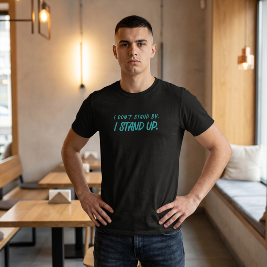 A man wearing a black graphic t-shirt with the text 'I DON'T STAND BY. I STAND UP.