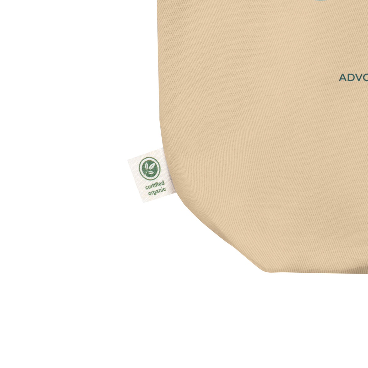Close-up of a beige woven fabric product corner with a small white Certified Organic tag attached, shown on a plain white background.