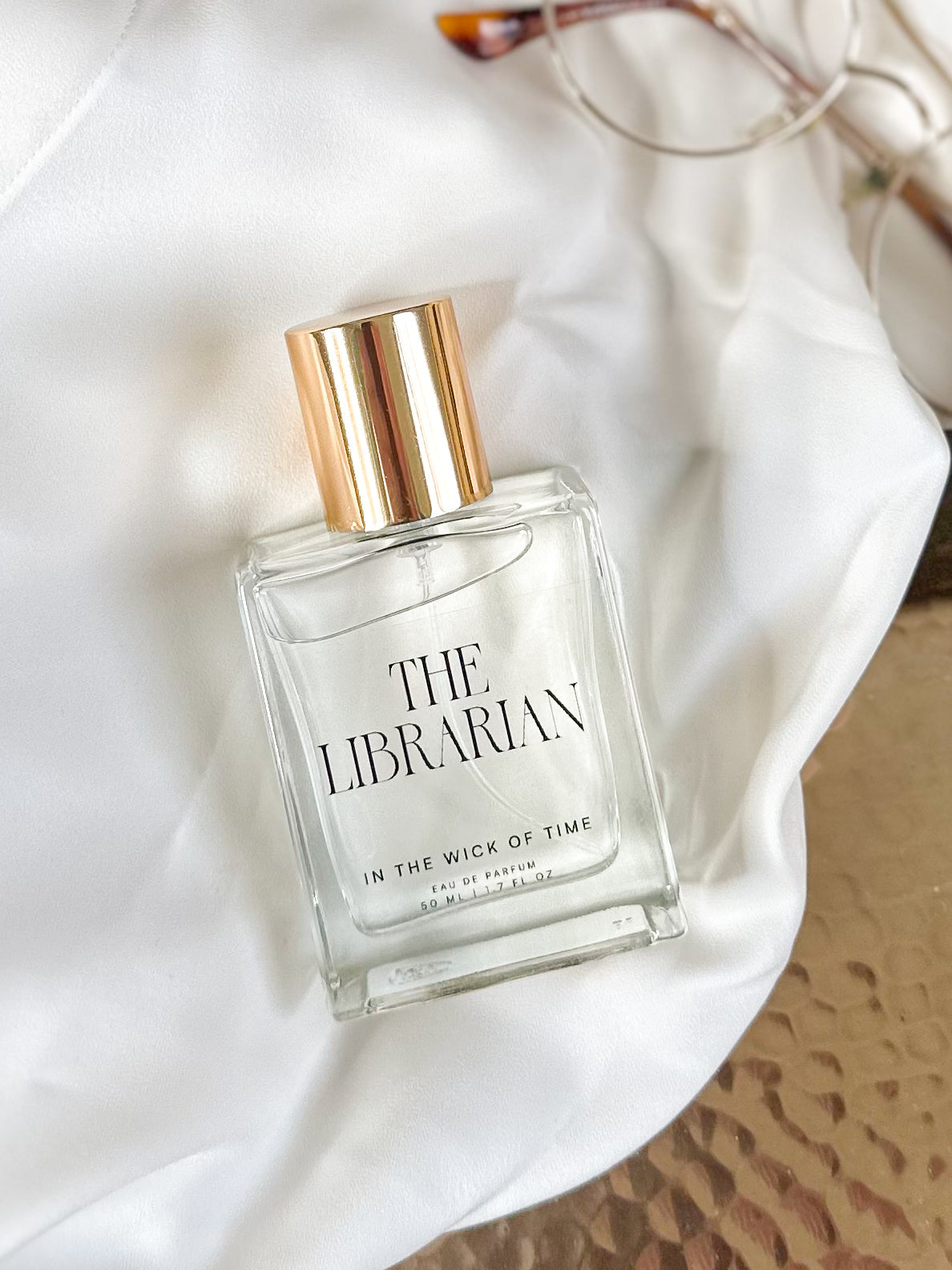 Perfume bottle labeled 'The Librarian' on a white fabric background