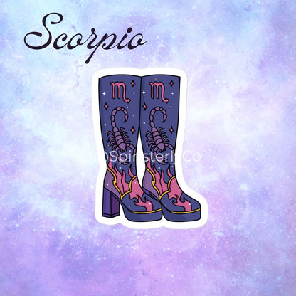 A die-cut sticker featuring a pair of purple high-heeled cowboy boots with pink and yellow flame details and the Scorpio symbol, set against a purple and blue galaxy background with the word 'Scorpio' written in script.