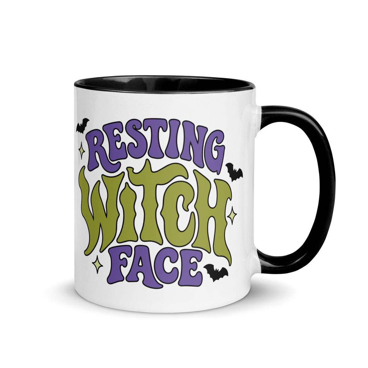 A white ceramic mug with a black handle and interior, featuring the text 'RESTING WITCH FACE' in purple and olive green gothic-style lettering with small black bats and yellow stars.