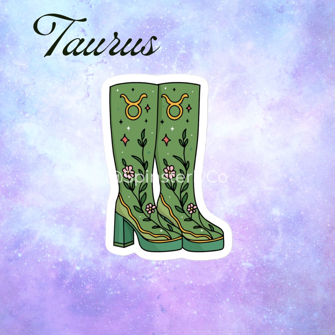 A die-cut sticker featuring a pair of green knee-high western boots with floral and zodiac symbol embroidery, shown on a pastel purple and blue galaxy background with the word 'Taurus' in script at the top.