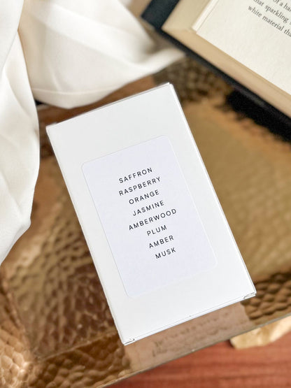 White box with fragrance name on a textured surface