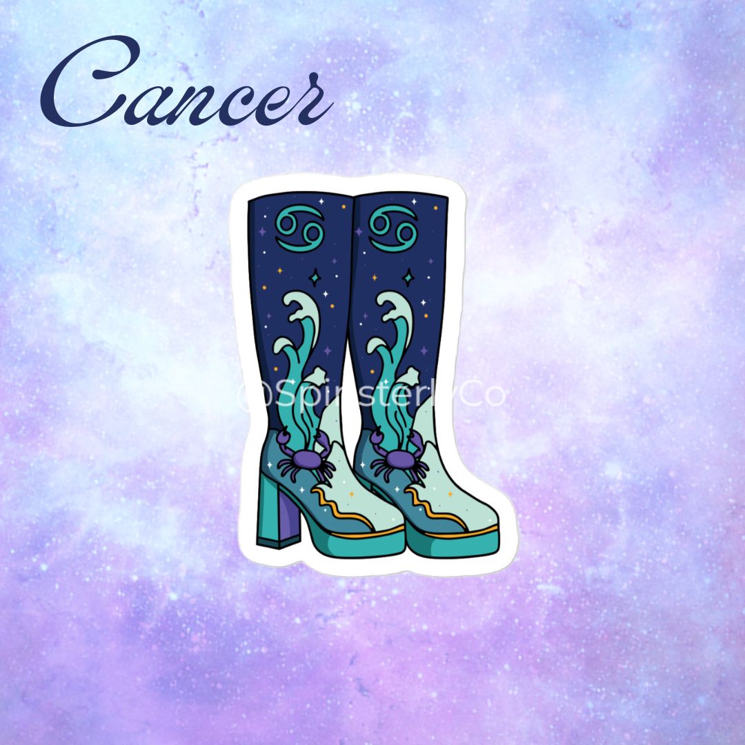 A die-cut sticker of a pair of tall cowboy boots with Cancer zodiac theme, featuring a dark blue starry background, teal wave patterns, purple crabs, and gold accents, displayed on a purple and blue galaxy background with the word 'Cancer' written in navy script.