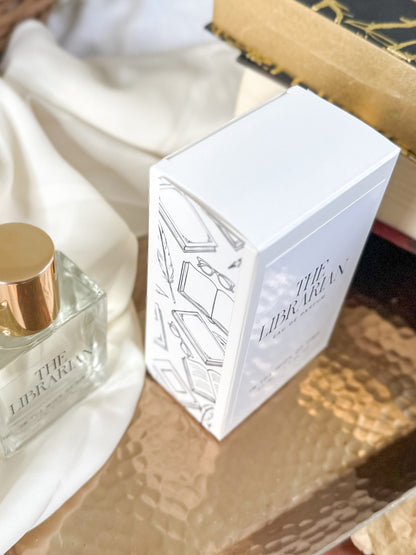 White box with 'The Librarian' branding on a wooden surface with a perfume bottle.