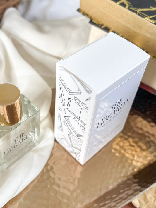White box with 'The Librarian' branding on a wooden surface with a perfume bottle.