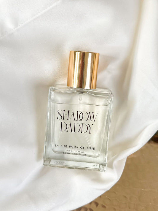 Perfume bottle labeled 'Shadow Daddy' on a white fabric background