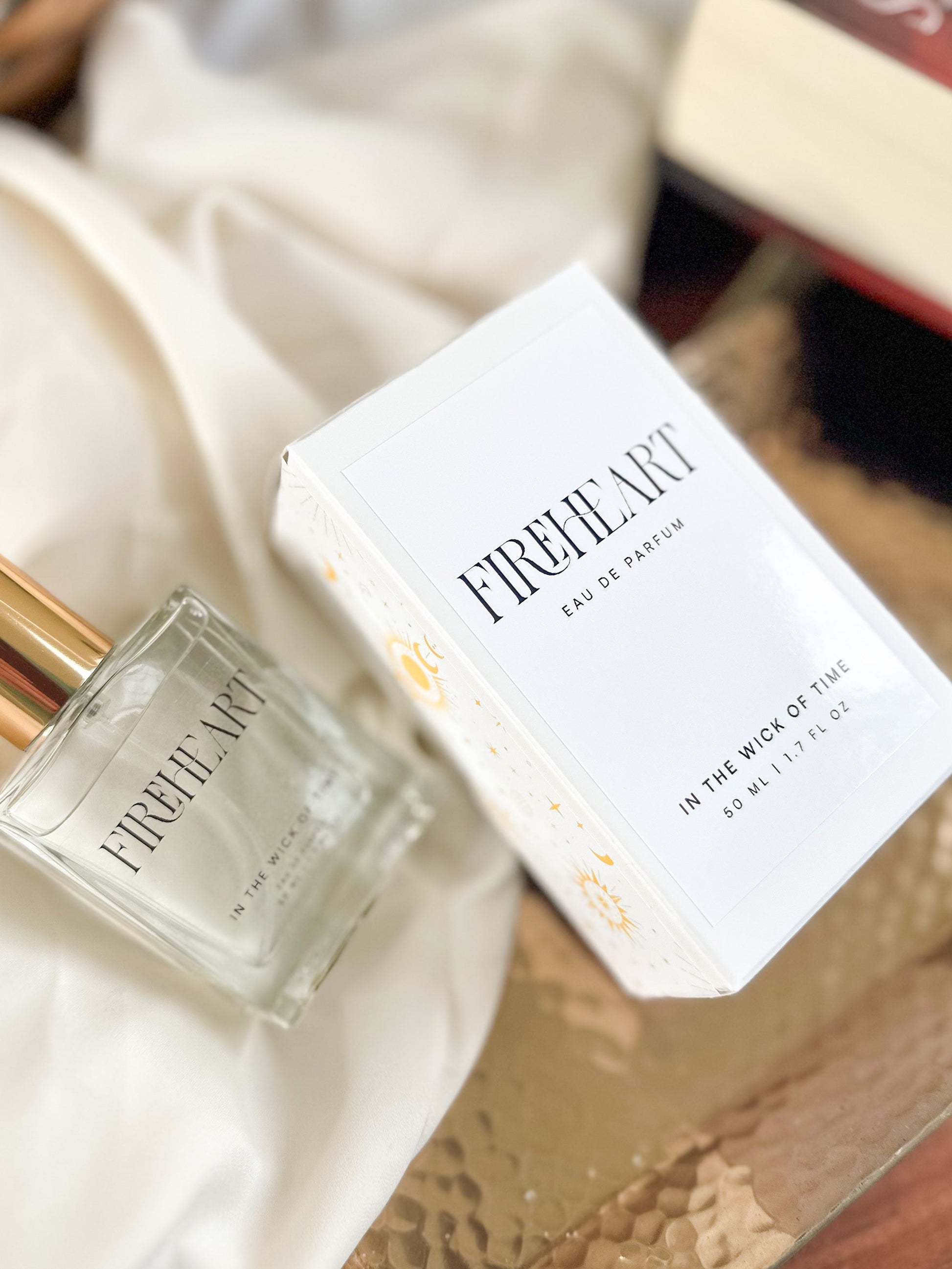 Fireheart perfume bottle and packaging on a textured surface