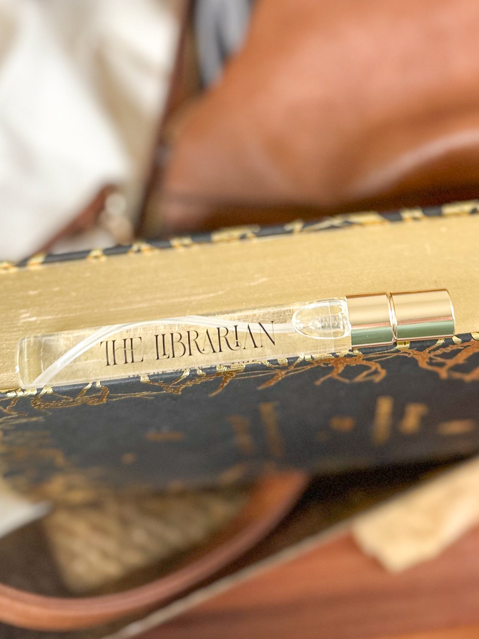 Small perfume bottle with gold cap on a decorative box