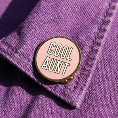 Pink 'Cool Aunt' pin on a purple denim jacket