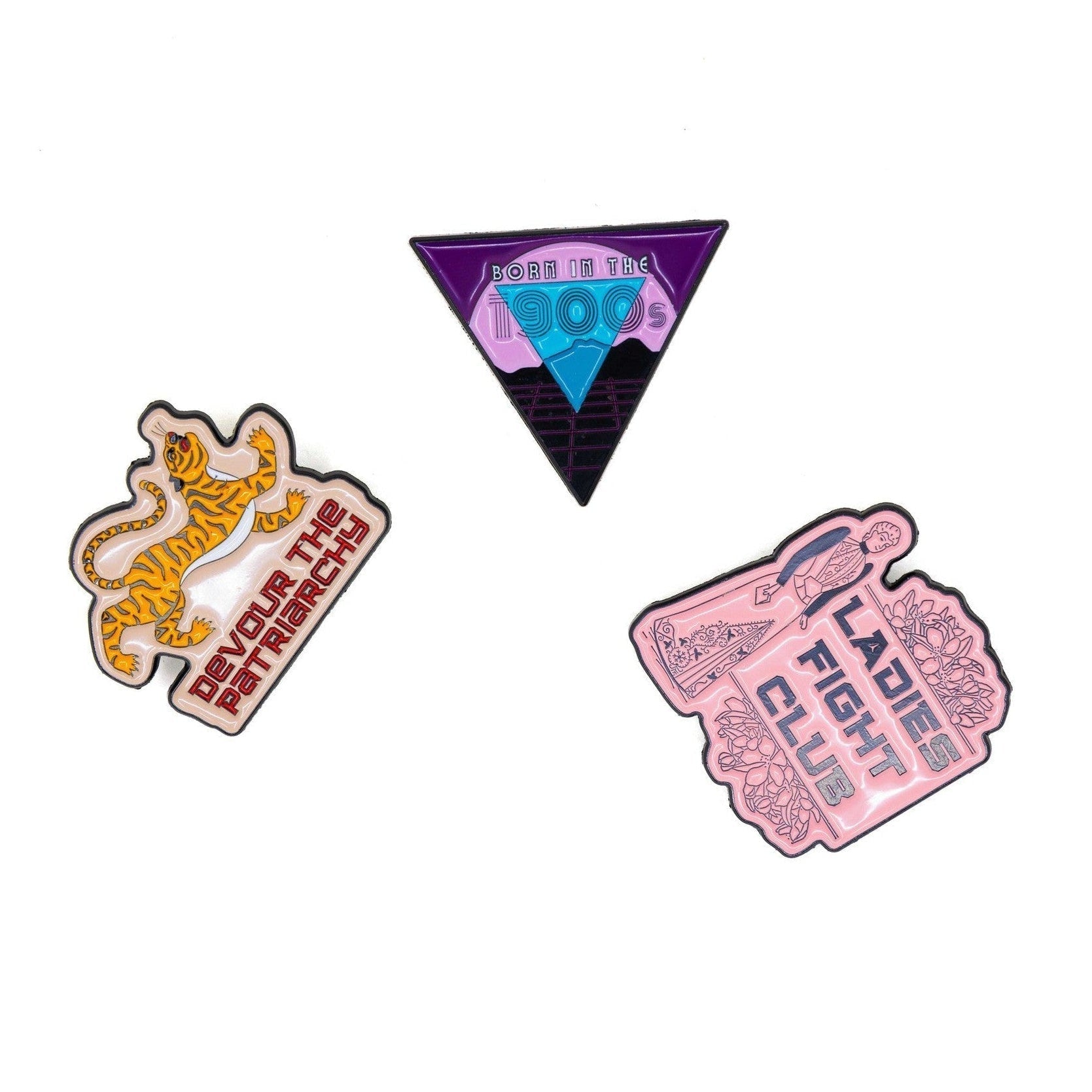 Three pins with different designs on a white background
