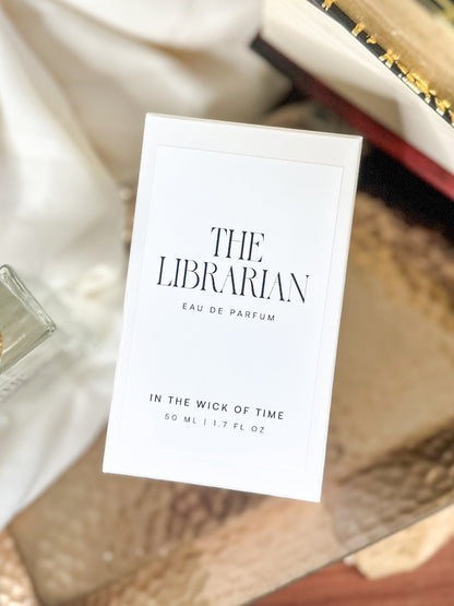 Perfume packaging with 'The Librarian' branding on a textured surface.