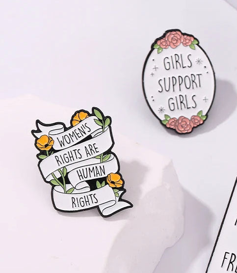 Pins with feminist-themed messages on a white background