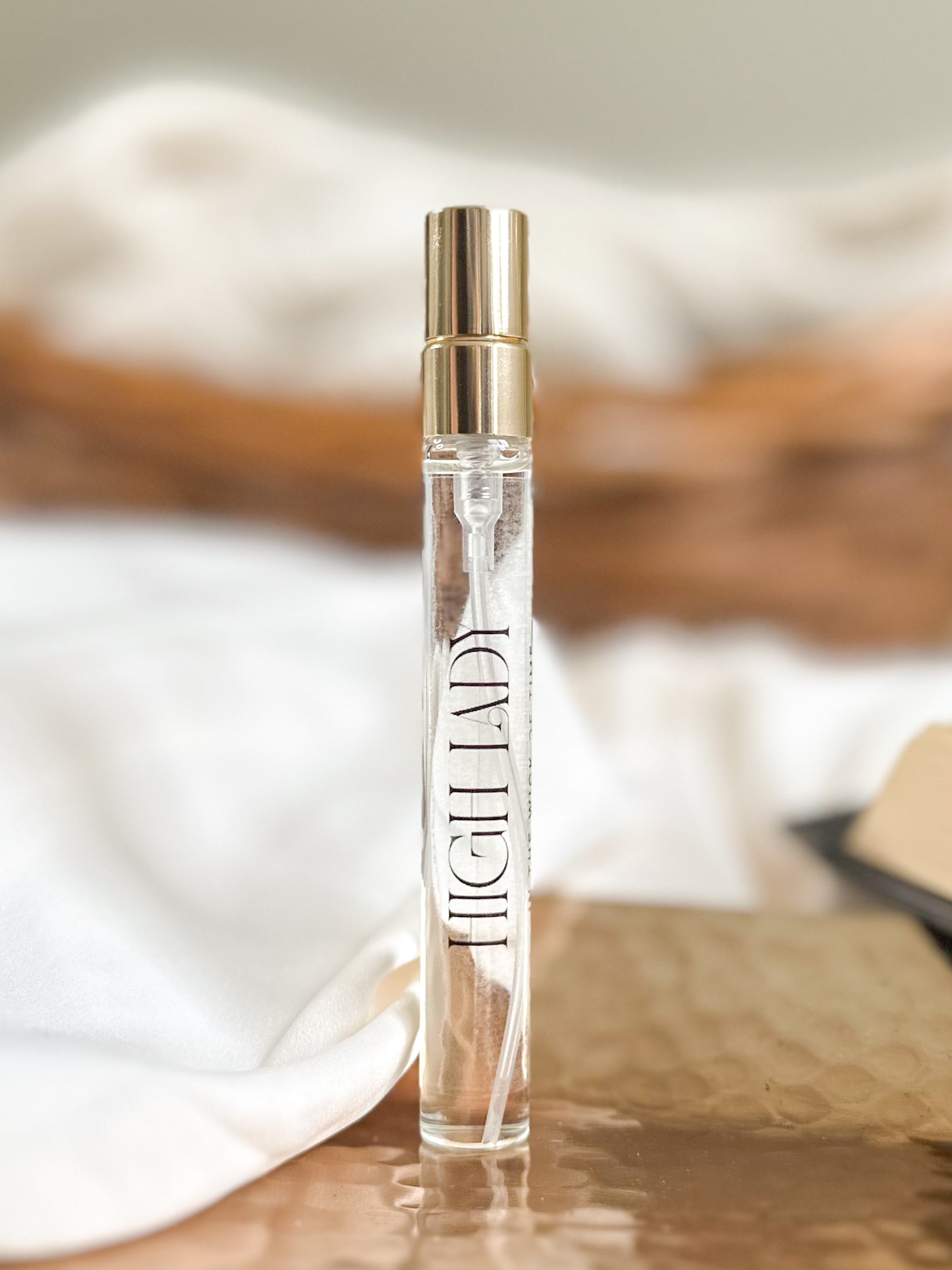 Perfume bottle labeled 'High Lady' on a wooden surface with a blurred background