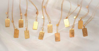Gold necklaces with rectangular pendants, each featuring a 1 of 12 zodiac signs, on a white background.