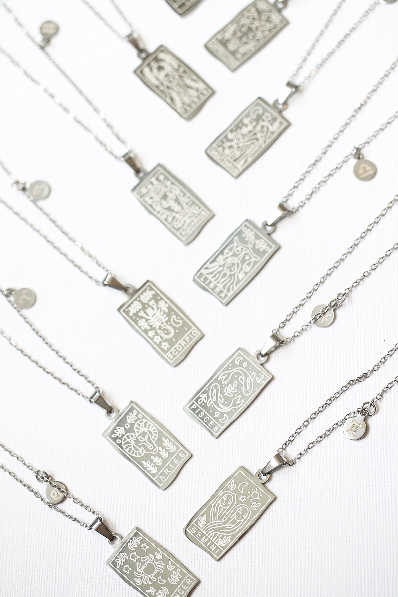 Silver necklaces with rectangular pendants on a white background