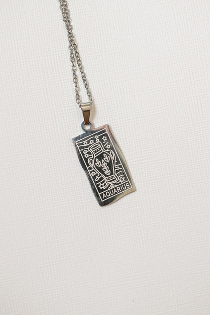 Aquarius zodiac sign pendant on a chain against a white background