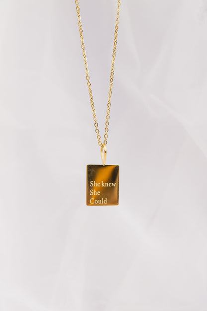 Gold necklace with a tiger's eye pendant on a white background