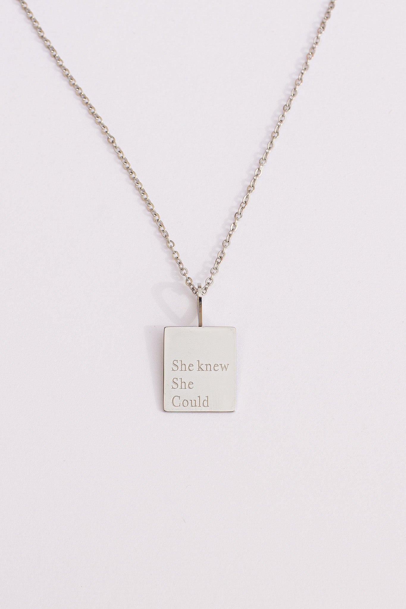 Necklace with a square pendant on a light gray background