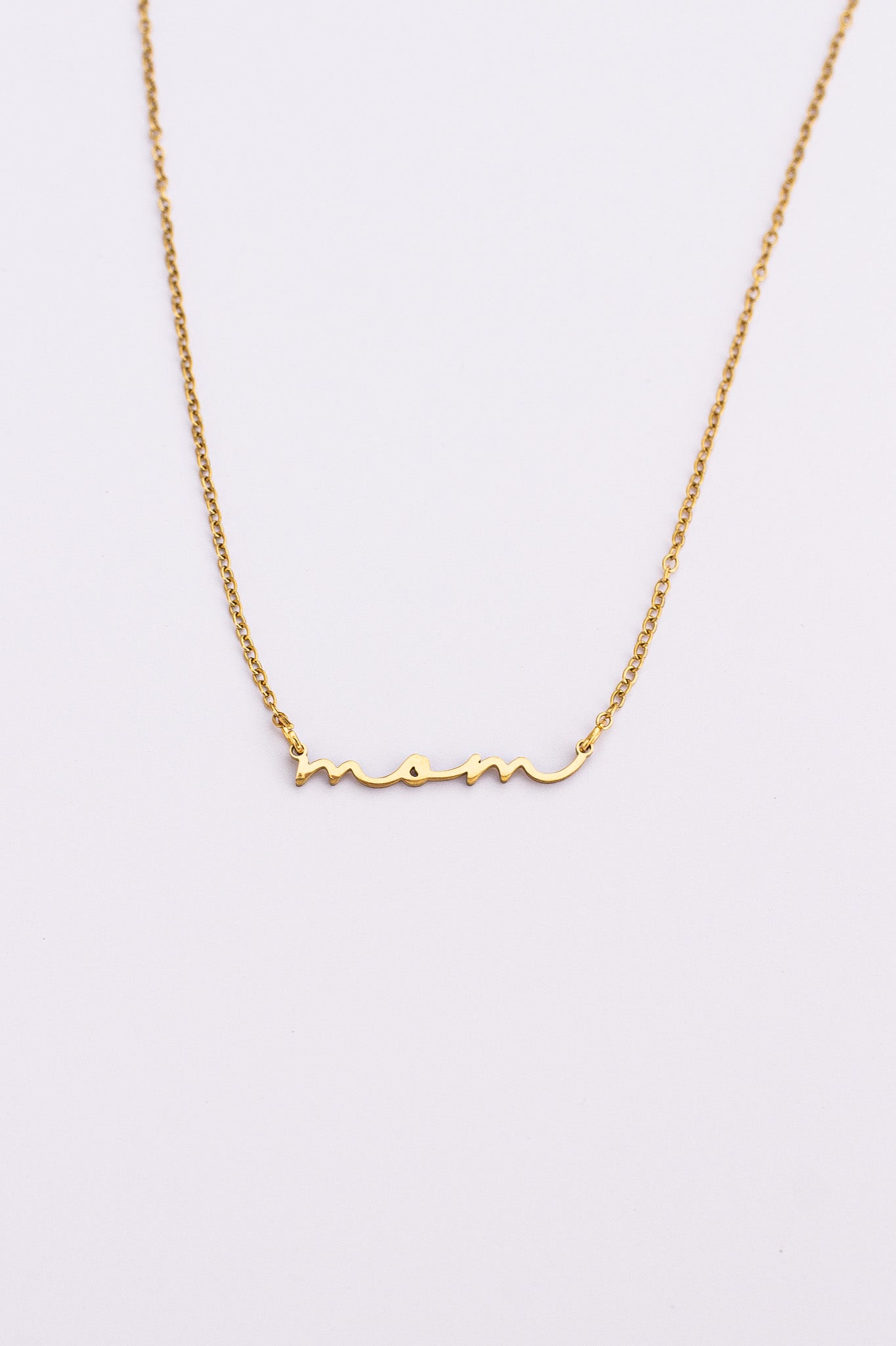 Gold necklace with 'mom' inscription on a light gray background