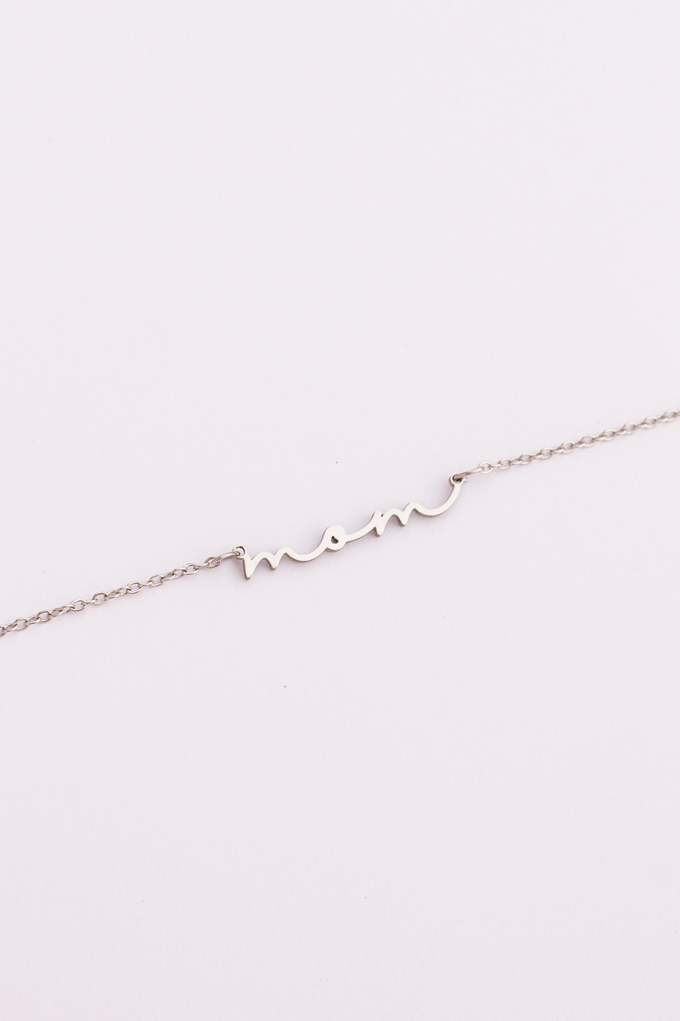 Delicate silver bracelet on a light pink background