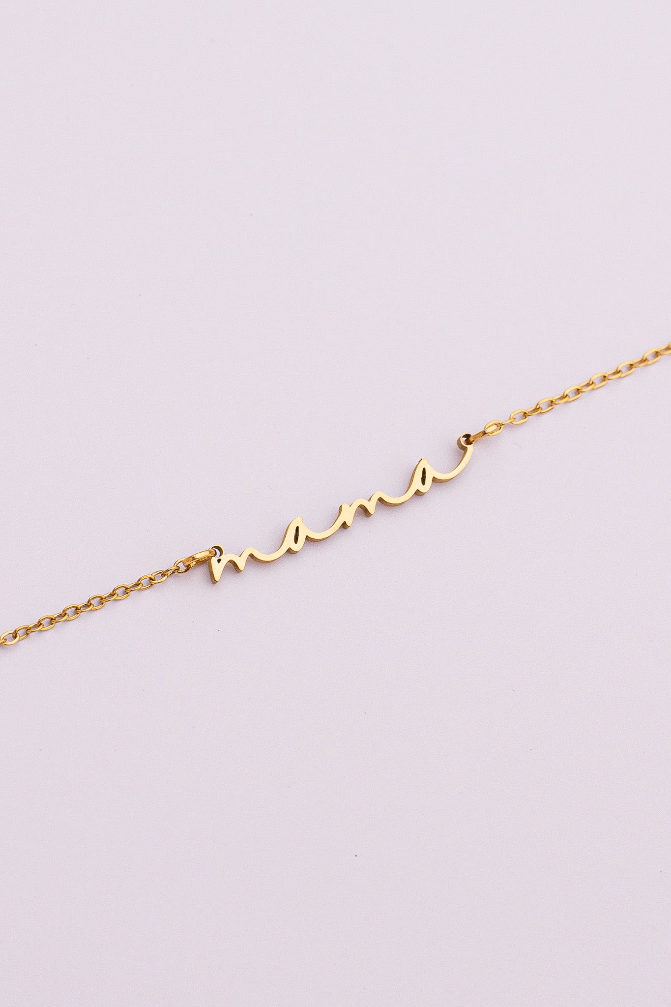 Gold bracelet with a unique design on a light purple background