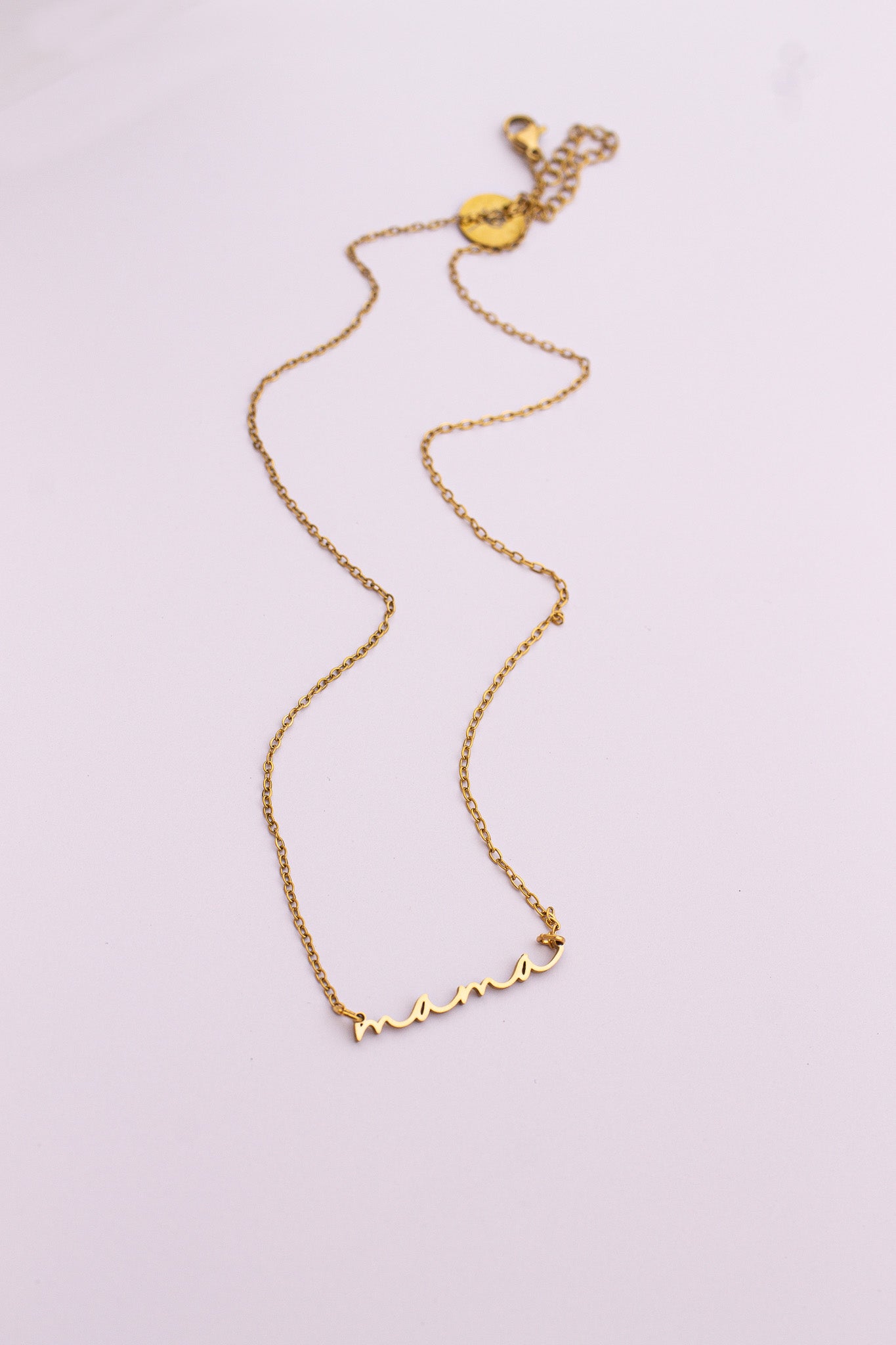 Gold necklace on a light purple background