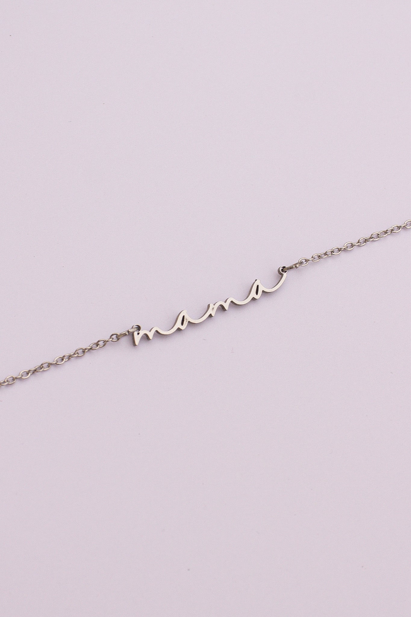 Silver bracelet with 'mom' on a light purple background