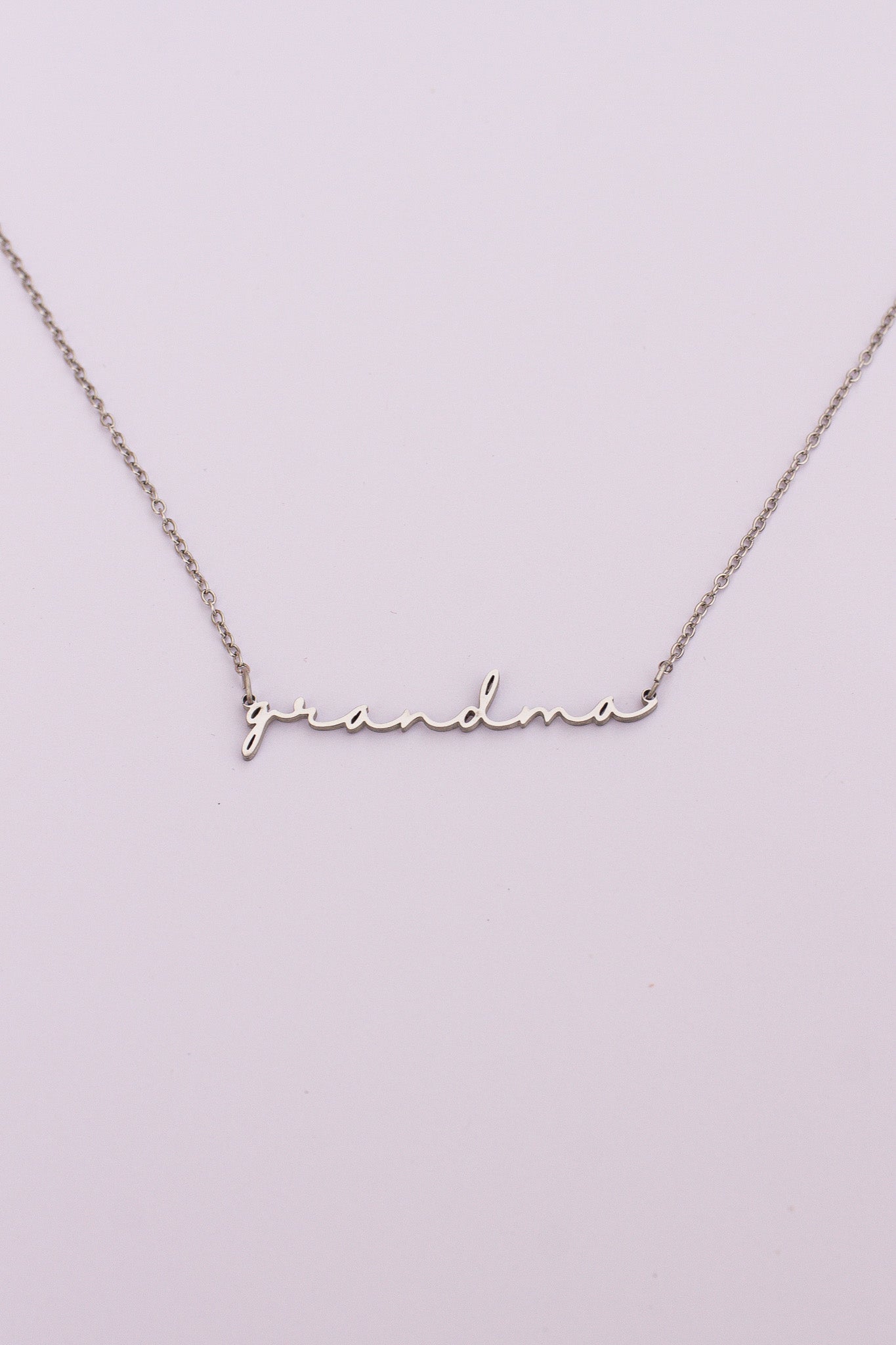 Silver 'grandma' necklace on a light purple background