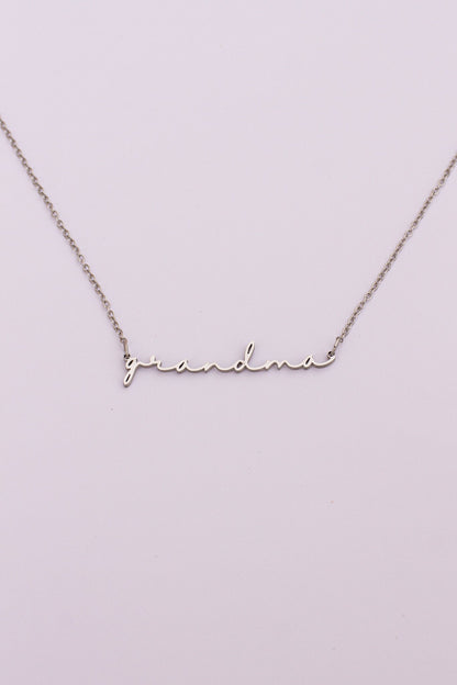 Silver 'grandma' necklace on a light purple background