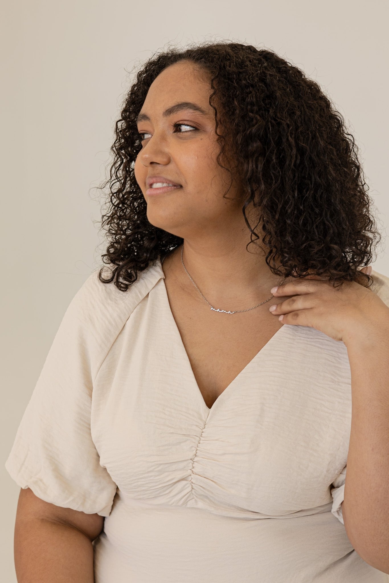 Woman wearing a beige dress with a plain background
