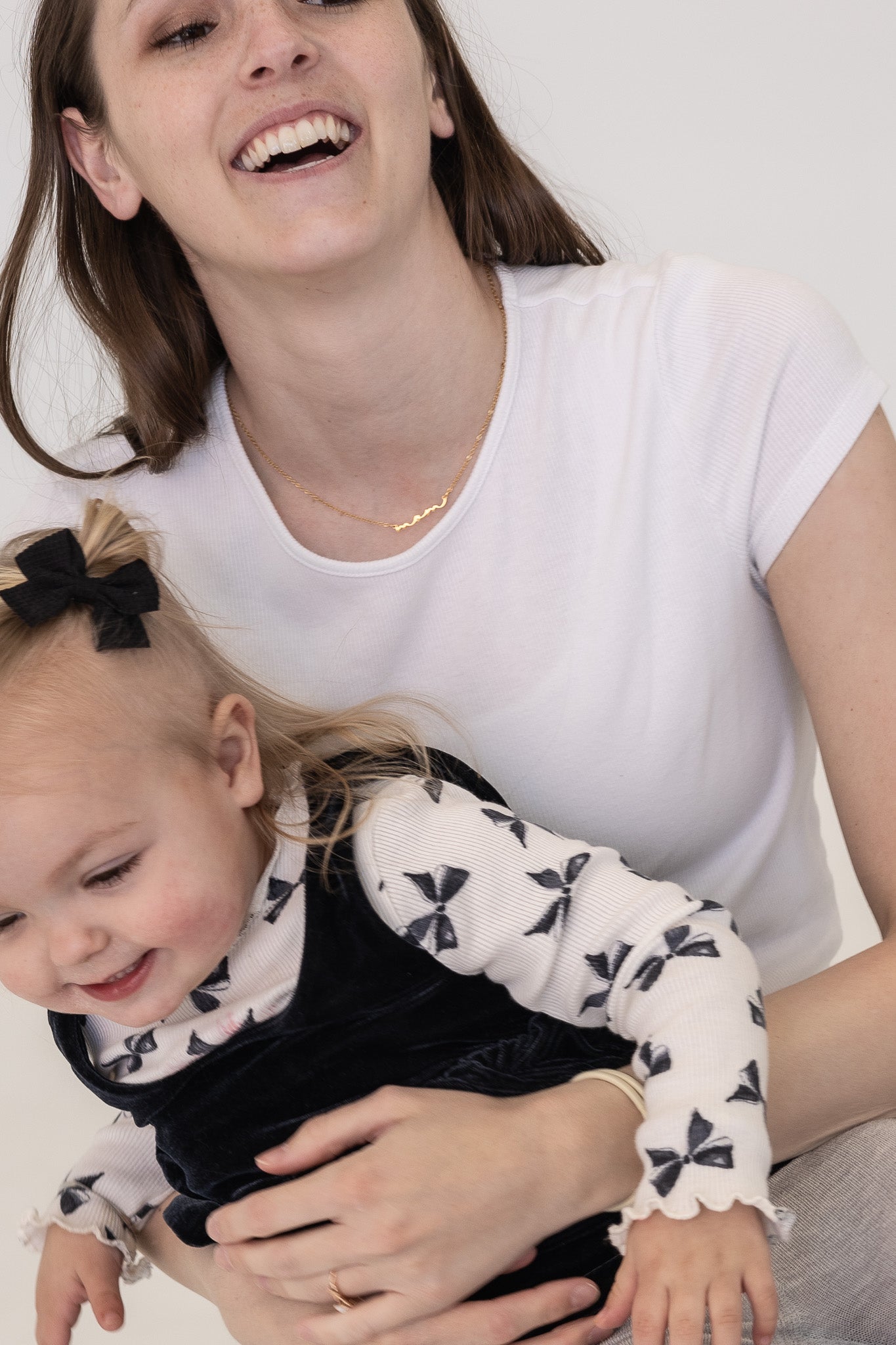 Woman holding a child against a white background