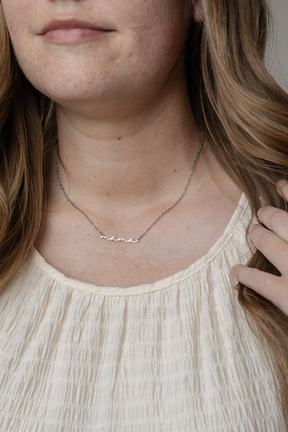 Necklace with small stones worn by a person with light skin and blonde hair.