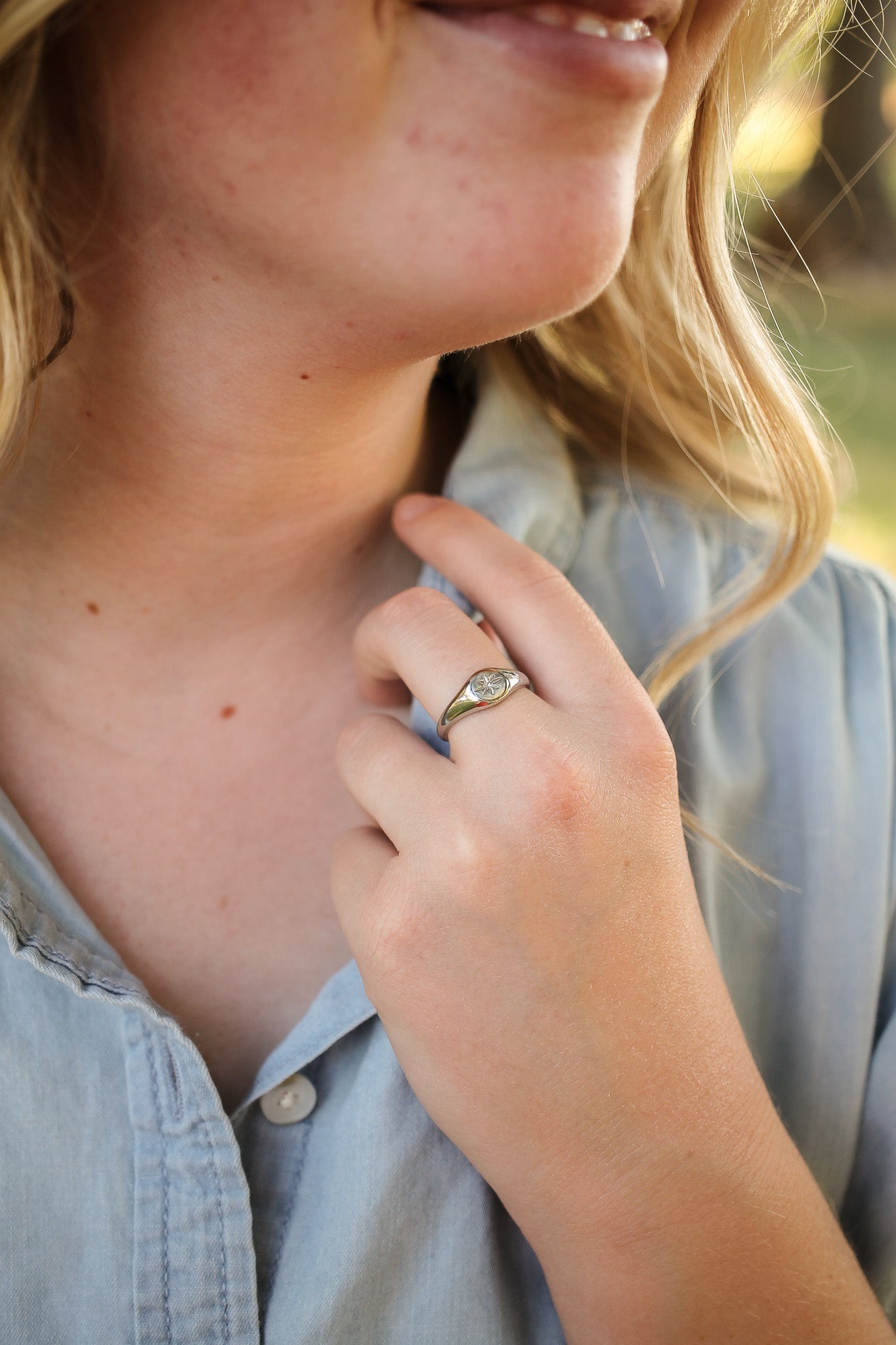 Close-up of a person wearing a ring with a blurred background