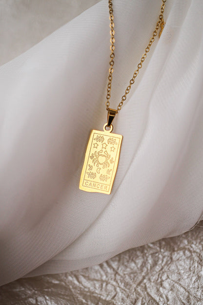 Gold pendant necklace on a soft fabric background