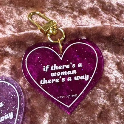 Heart-shaped keychain with motivational quote on a textured surface