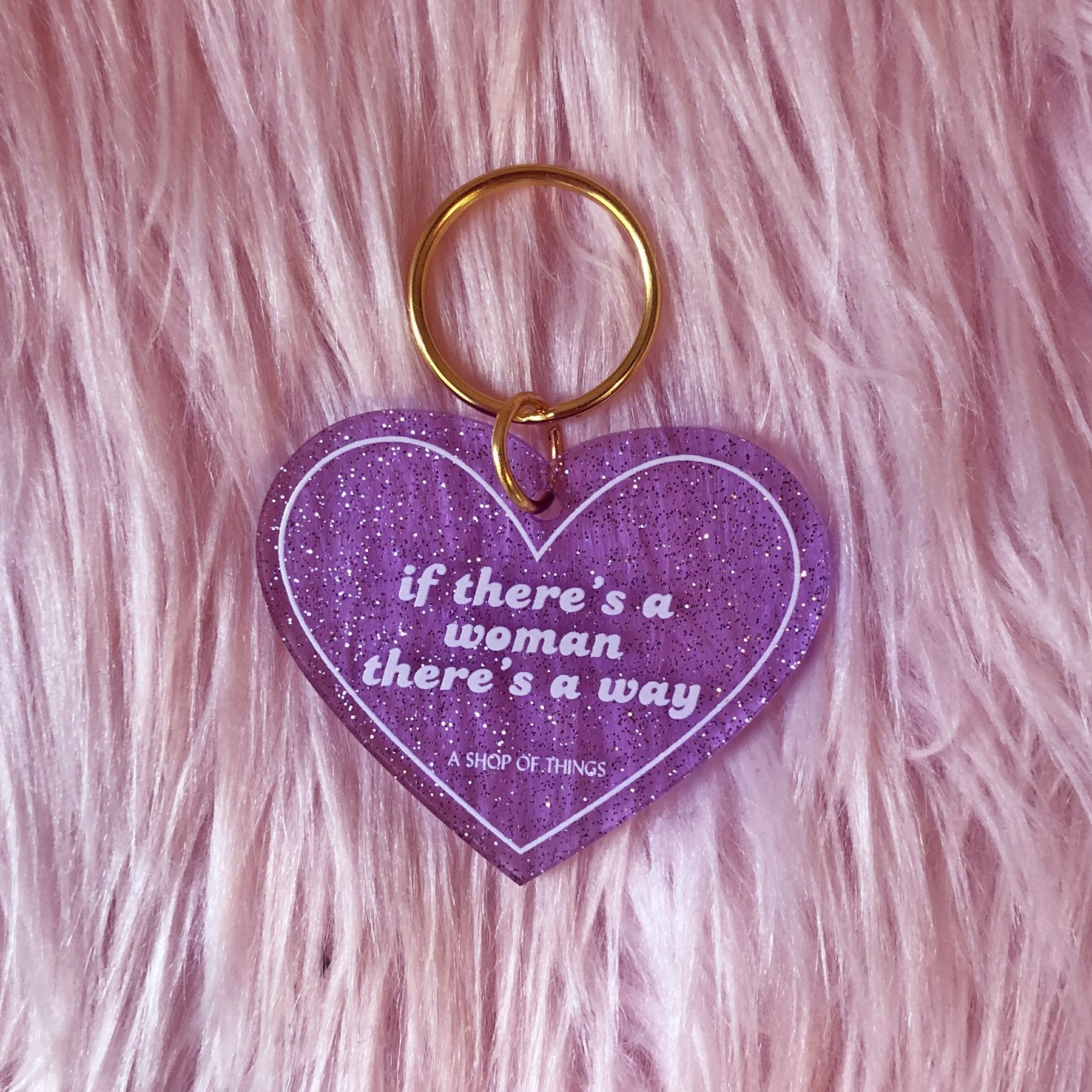 Heart-shaped keychain with motivational quote on a pink fluffy background