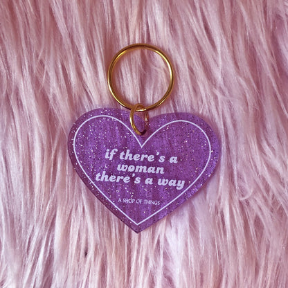 Heart-shaped keychain with motivational quote on a pink fluffy background