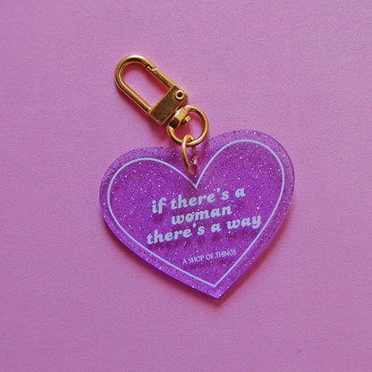 Heart-shaped keychain with motivational quote on a pink background