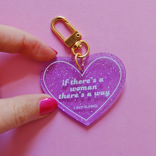 Heart-shaped keychain with motivational quote on a pink background