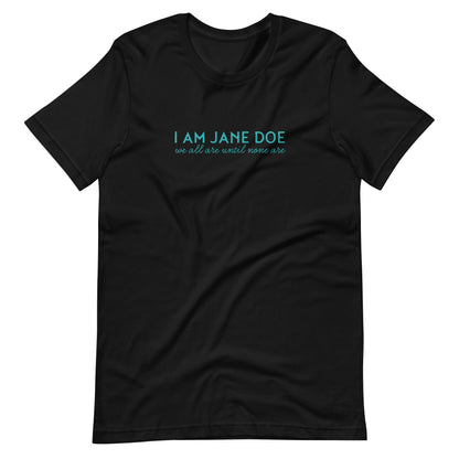 A black short-sleeve crewneck t-shirt with a teal graphic text print on the chest reading 'I AM JANE DOE' and 'we all are until none are', displayed flat against a solid white background.