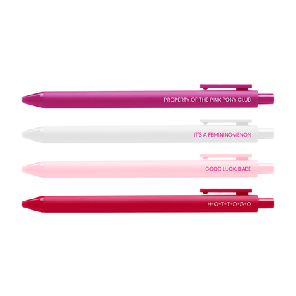 Three retractable pen-style items arranged vertically on a white background, each with its reflection below. The top pen is magenta/pink with white text reading 'PROPERTY OF THE PINK PONY CLUB'; the middle pen is white with white text reading 'IT'S A FEMINOMENON'; the bottom pen is bright pink/red with white text reading 'GOOD LUCK, BABE'.