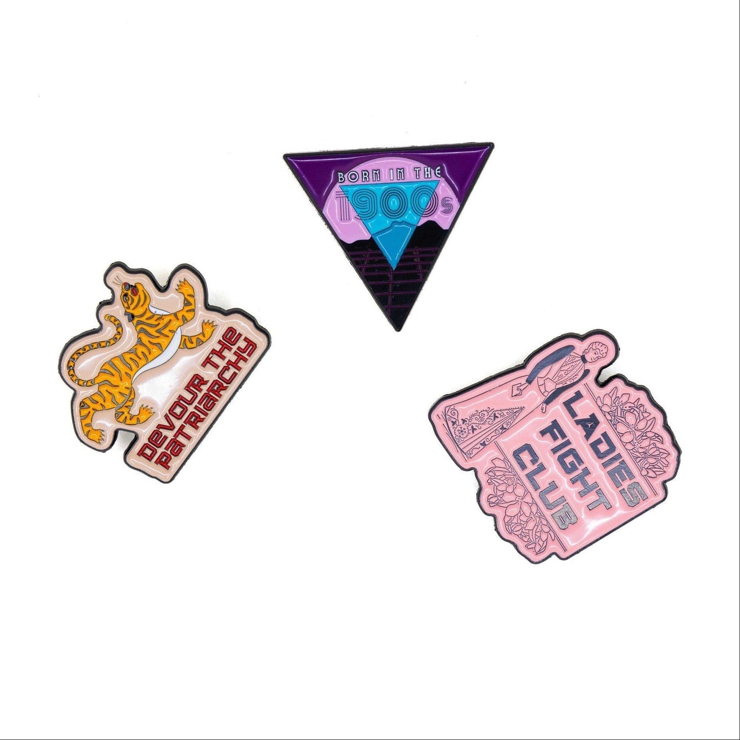 Three colorful enamel pins on a white background