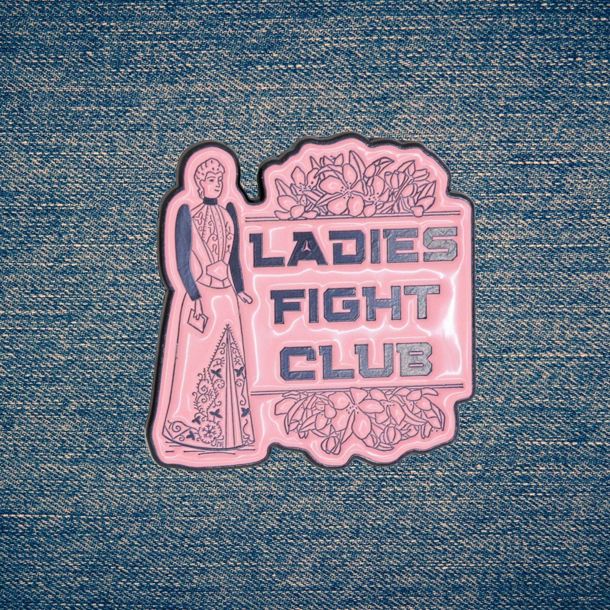 Pink 'Ladies Fight Club' sticker on denim fabric