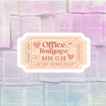 A stylized promotional graphic for an 'Office Romance Book Club' with a central ticket-shaped badge reading 'ADMIT ONE Office Romance BOOK CLUB LIFETIME MEMBERSHIP' over a soft pastel background of stacked books.