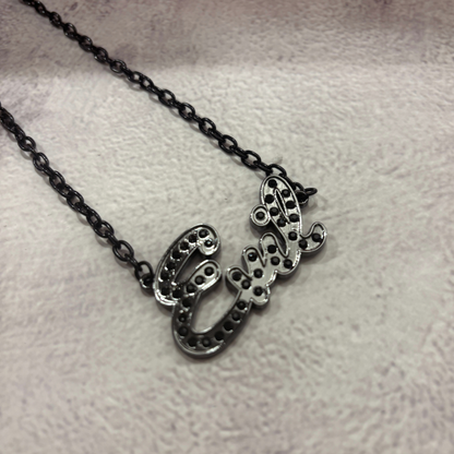 Silver necklace with a decorative pendant on a light gray background